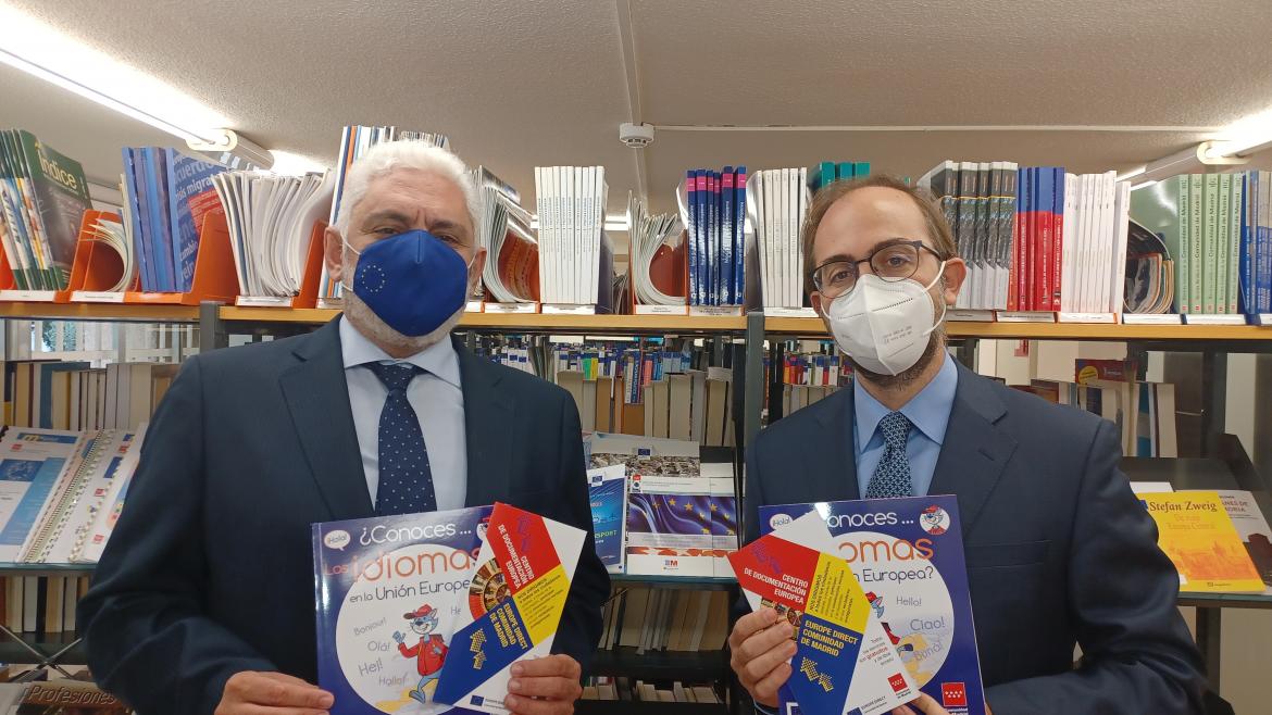 Dos personas posando con un libro en la mano