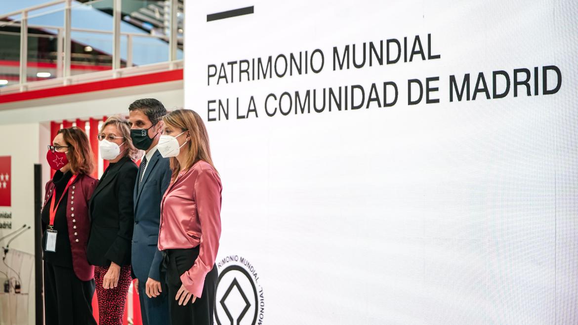 Los principales responsables posando junto a un mural donde se lee Patrimonio Mundial en la Comunidad de Madrid