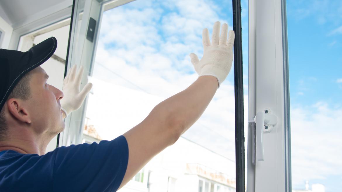 Persona conlocando cristal en una ventana
