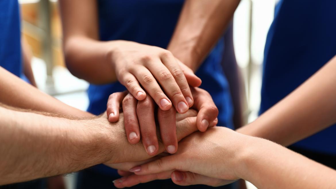 Voluntarios uniendo sus manos