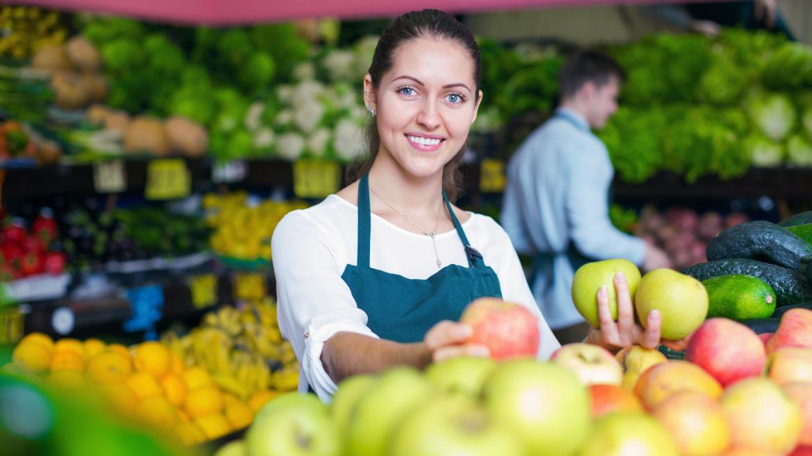 Una mujer frutera dentro de su negocio