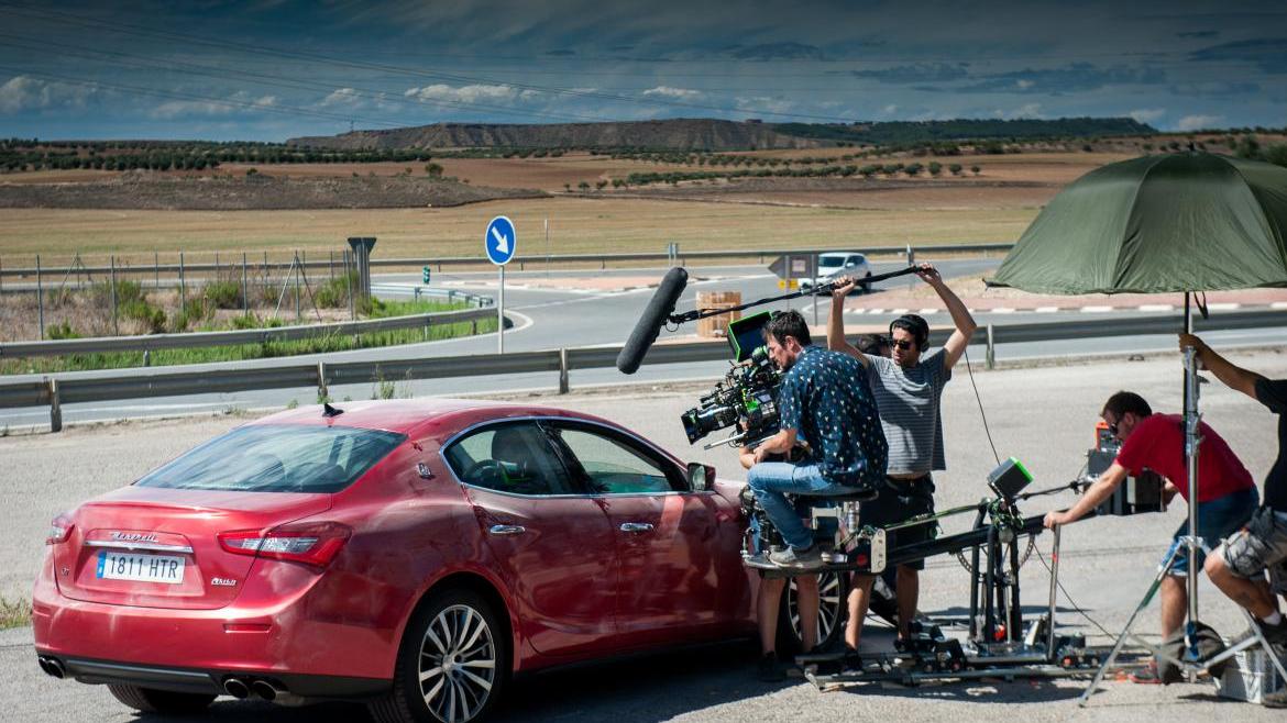 Equipo de cámaras de cine graban una escena con un coche Equipo de cámaras de cine graban una escena con un coche