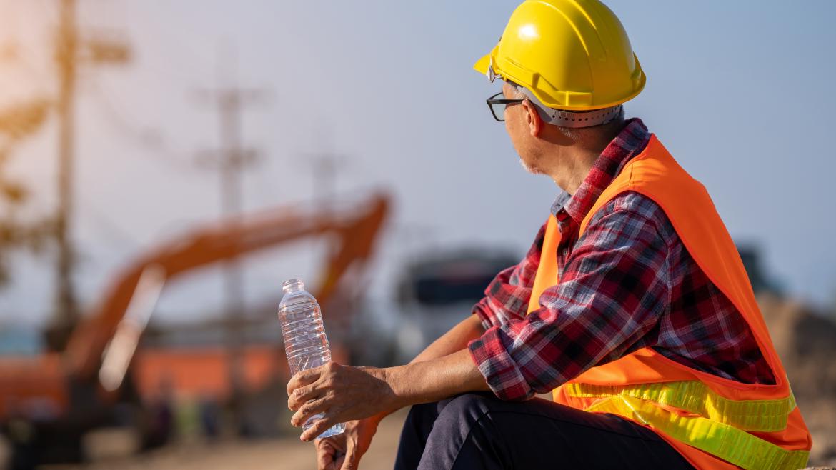 Trabajador de la construcción bebiendo agua por el calor