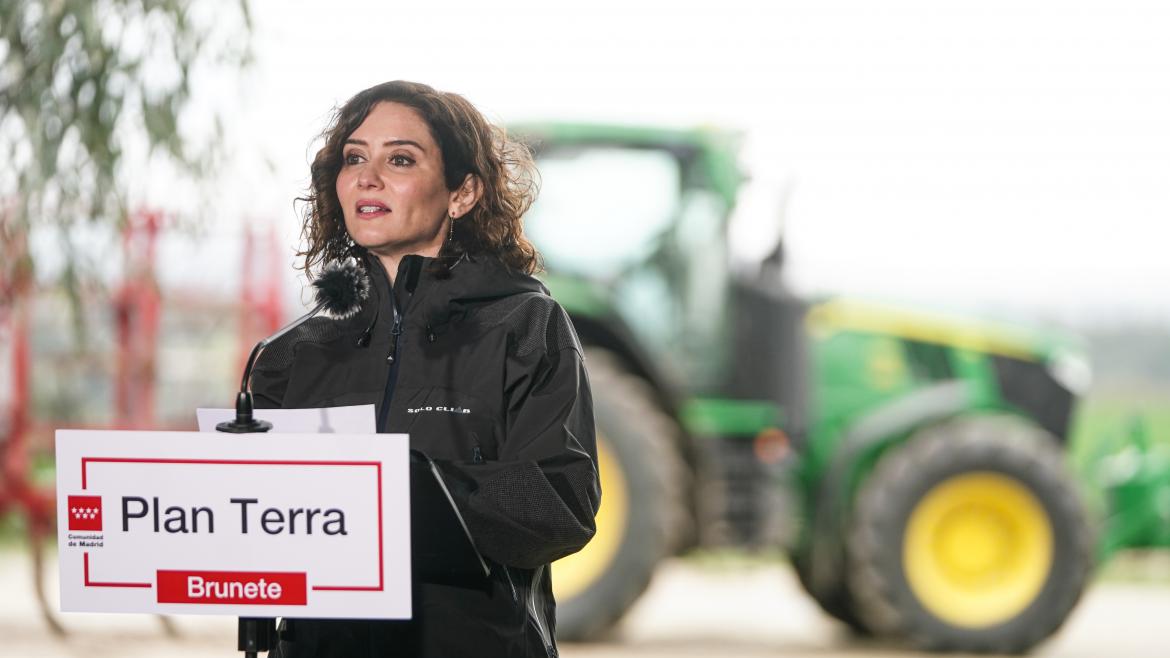 La pesidenta hablando desde el atril con un tractor detrás