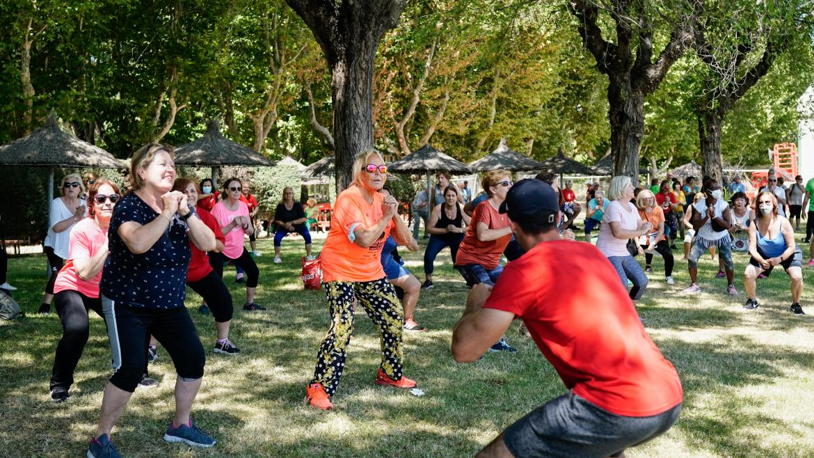 La Comunidad de Madrid concluye la temporada del programa de actividad física para mayores Enforma, con más de 2.400 usuarios Un entrenador da una clase a un grupo de personas mayores en un parque con árboles
