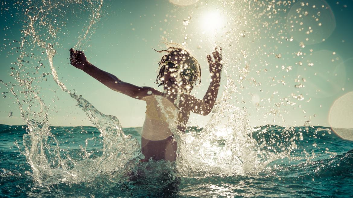 La Comunidad de Madrid inicia la XVI edición del programa Vacaciones en Familia para niños tutelados Un niño jugando en el mar