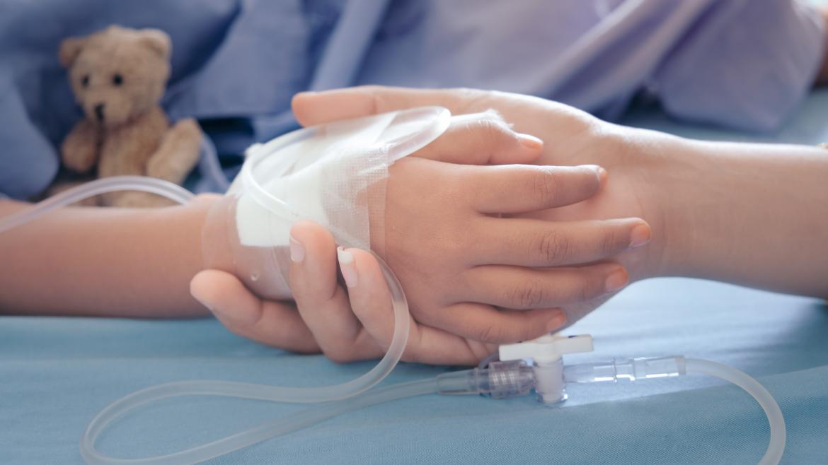 Una mano de un niño está siendo cogida por la de un adulto