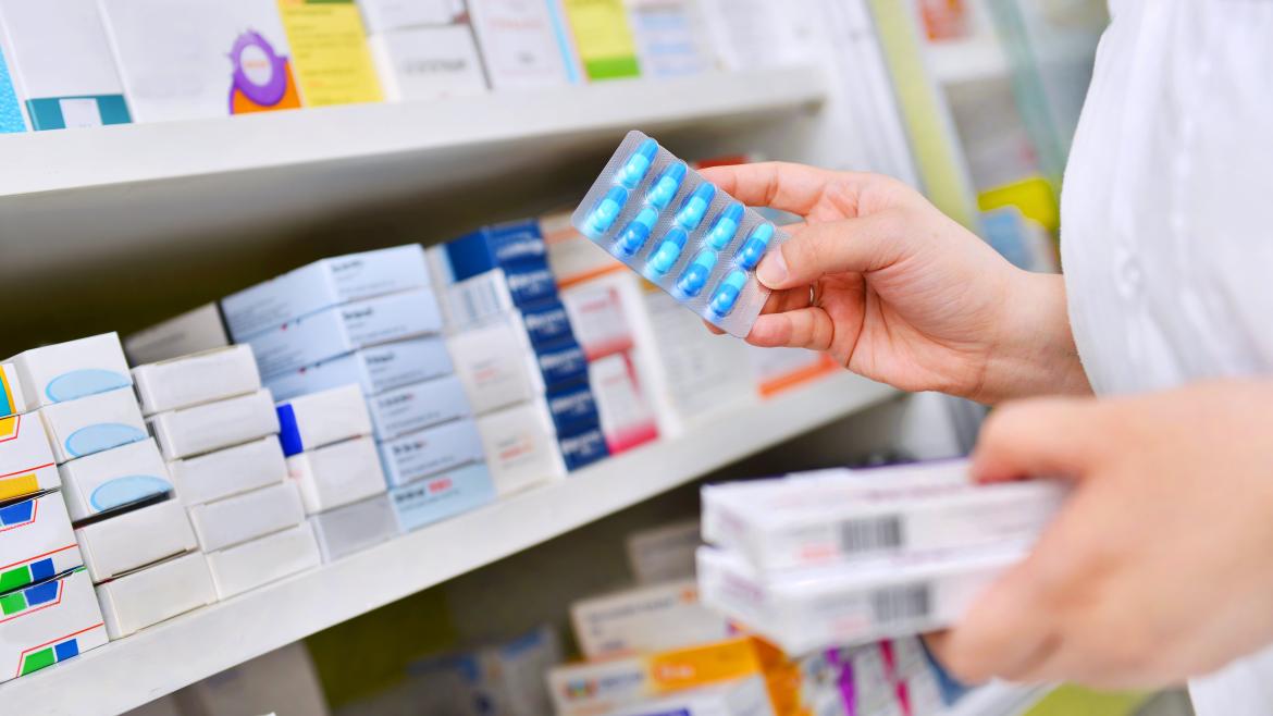 Las manos de una farmaceútica cogiendo unas cajas de medicinas