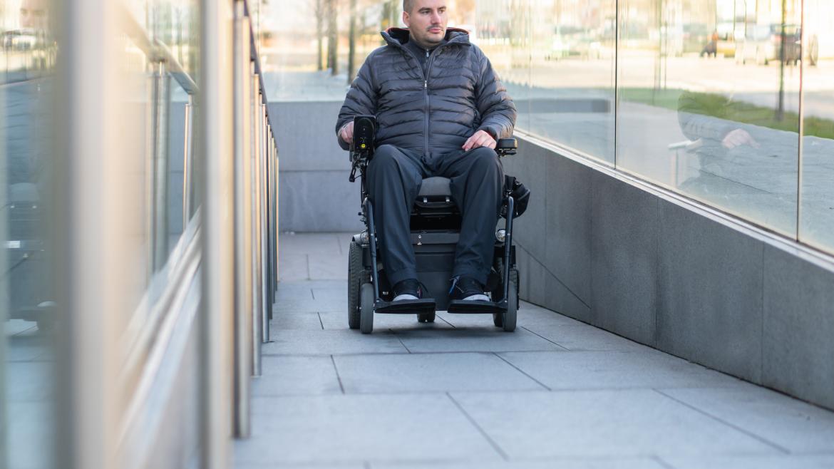 Hombre subiendo rampa en silla de ruedas eléctrica