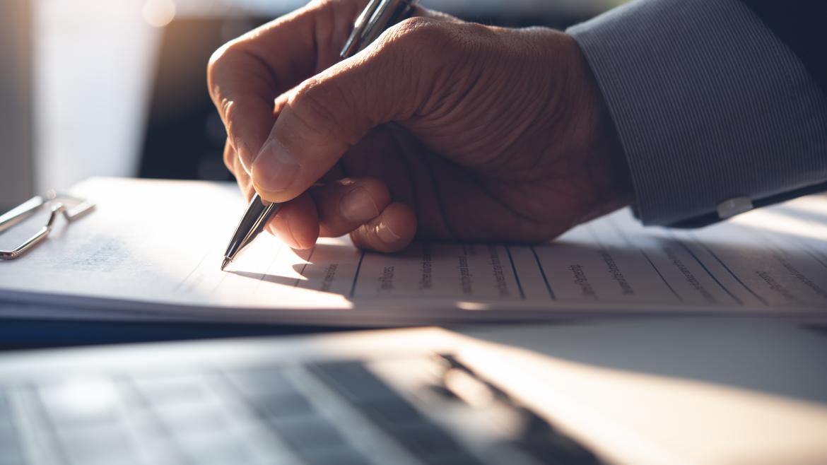 Una persona firmando un documento