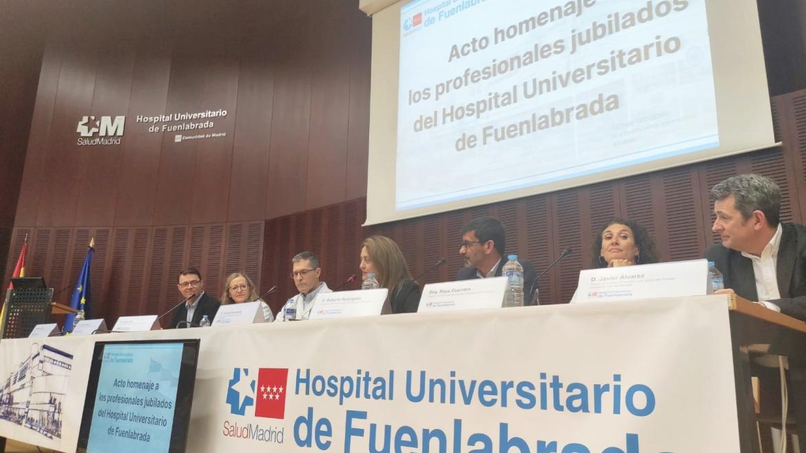 Personas sentadas en una mesa en un salón de actos