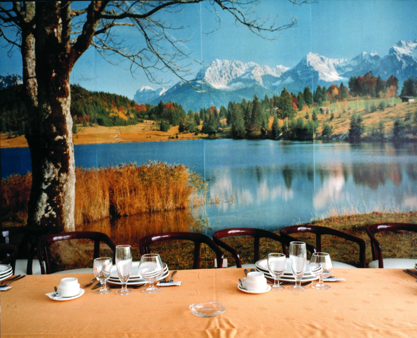 Manuel Sendón Sin título (Serie: Paisaxes), 1989-1991. Colección Museo CA2M Mesa con vasos y tazas frente aun paisaje de montañas y un lago