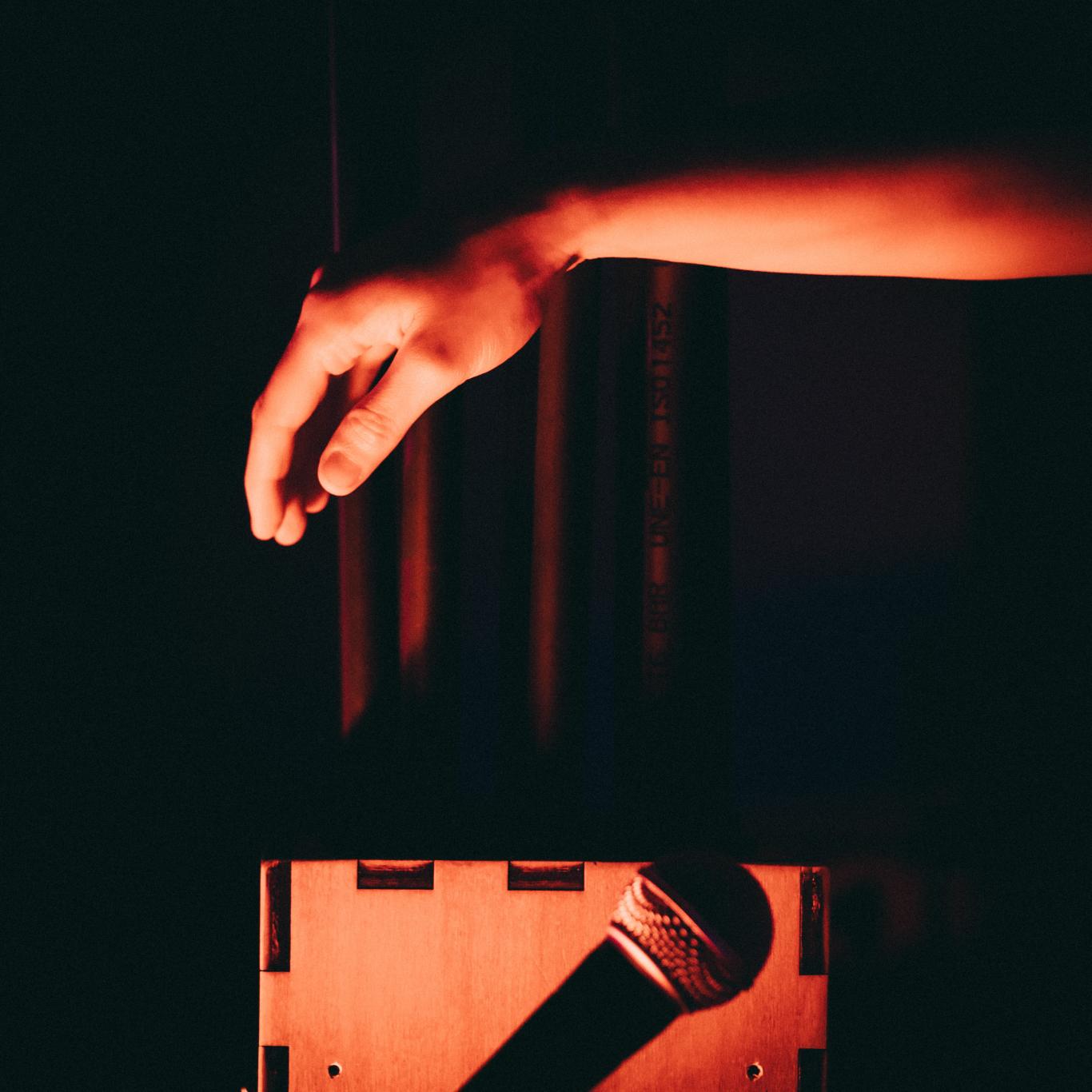Mano sobre fondo oscuro que va a tocar un instrumento musical