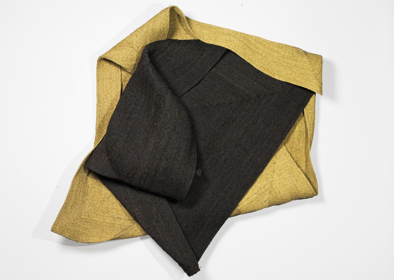 “Spartaria trenza”, 2024. Esparto trenzado y cosido. Colección Jesús Egea ©Sonia Navarro. VEGAP, Madrid, 2025. Foto: Jesús Madriñán. Escultura hecha con figuras geométicas que proyectan su sombra sobre un fondo oscuro