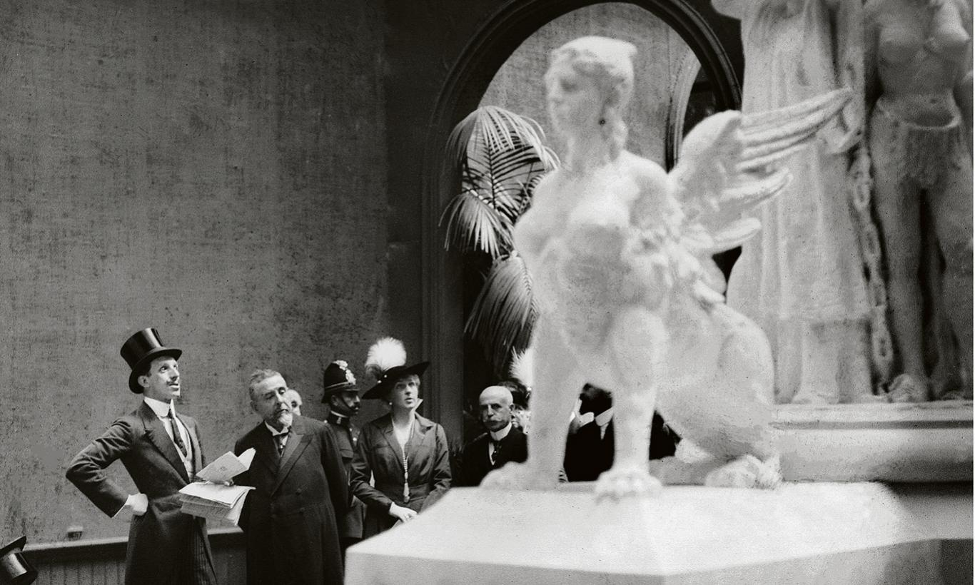 Personalidades contemplando escultura en una exposición