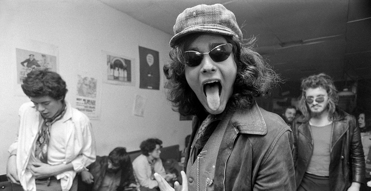 Hombre con gorra y gafas de sol saca la lengua al fotógrafo