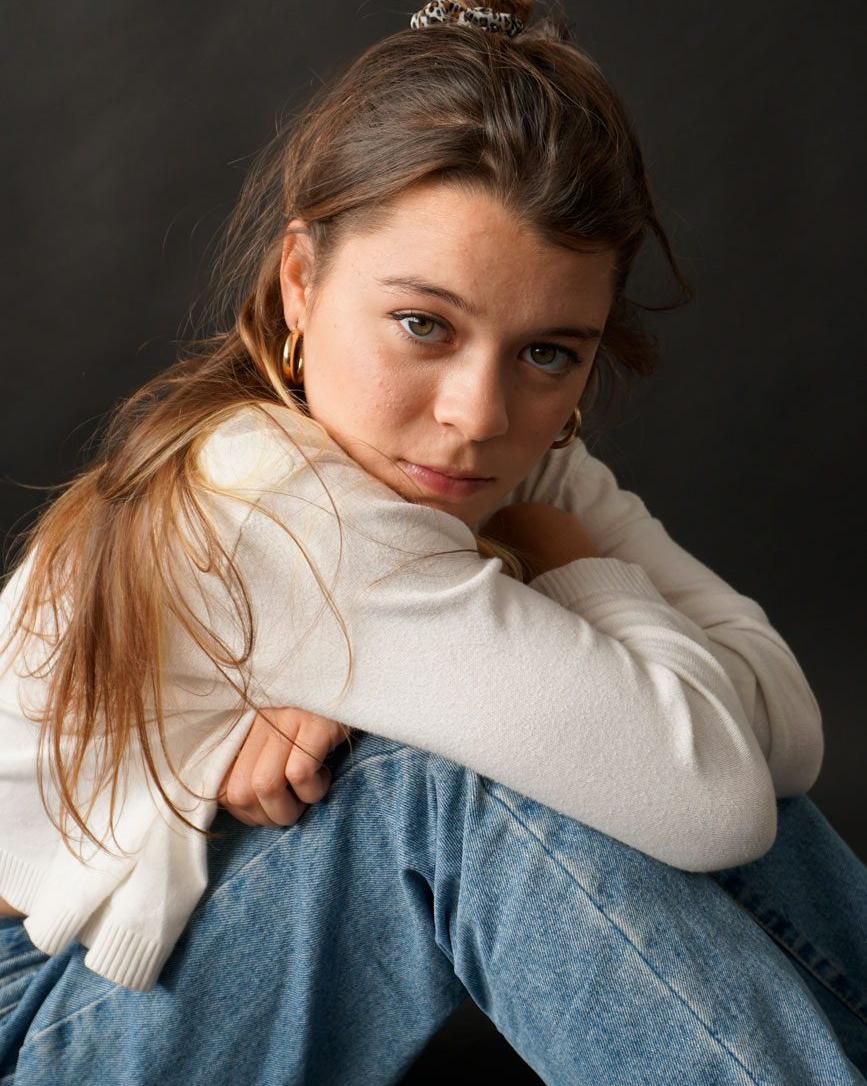 Mujer joven sentada cogiéndose las rodillas