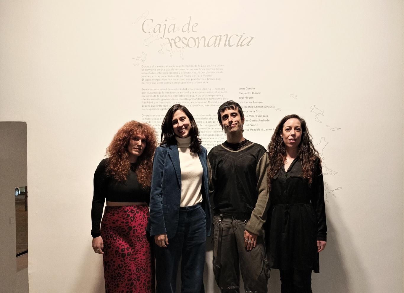 Grupo de gente joven posando frente a un texto en una sala de exposiciones donde se lee el título de la exposición Un cambio de paradigma