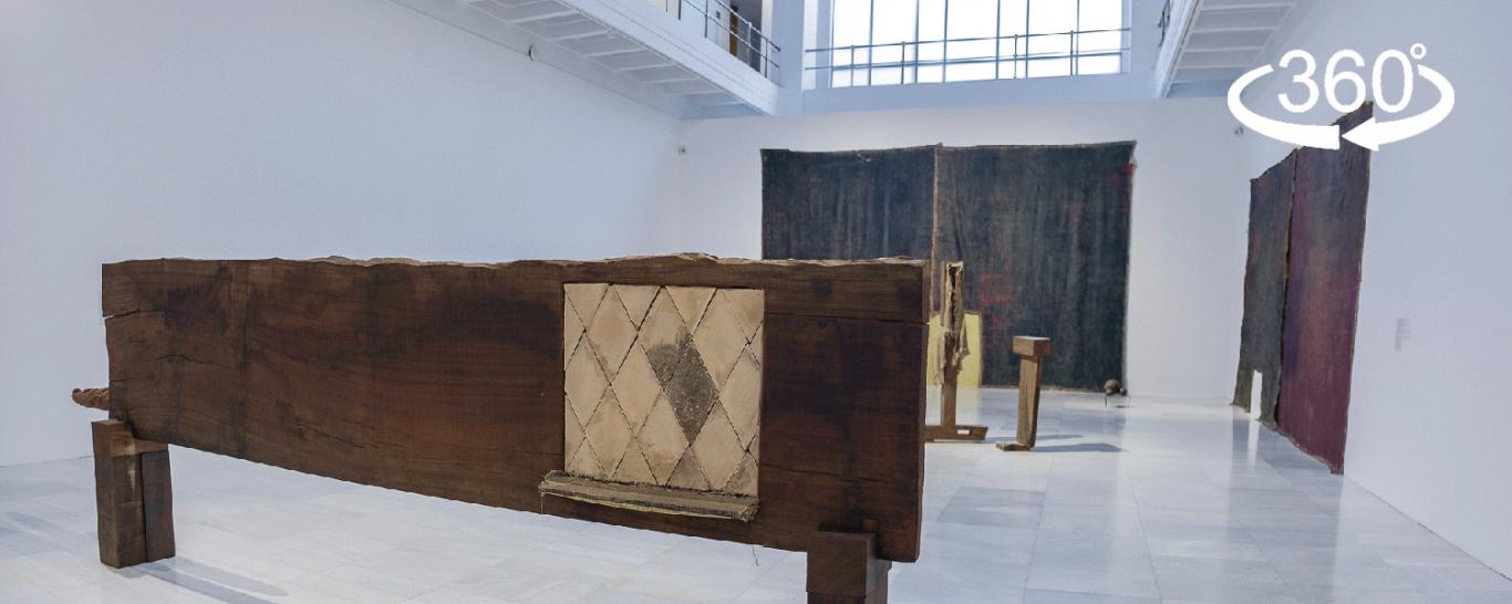 Vista de una sala de exposiciones con esculturas de madera