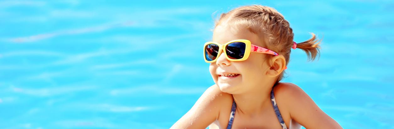 Niña sonriente en el borde de la piscina