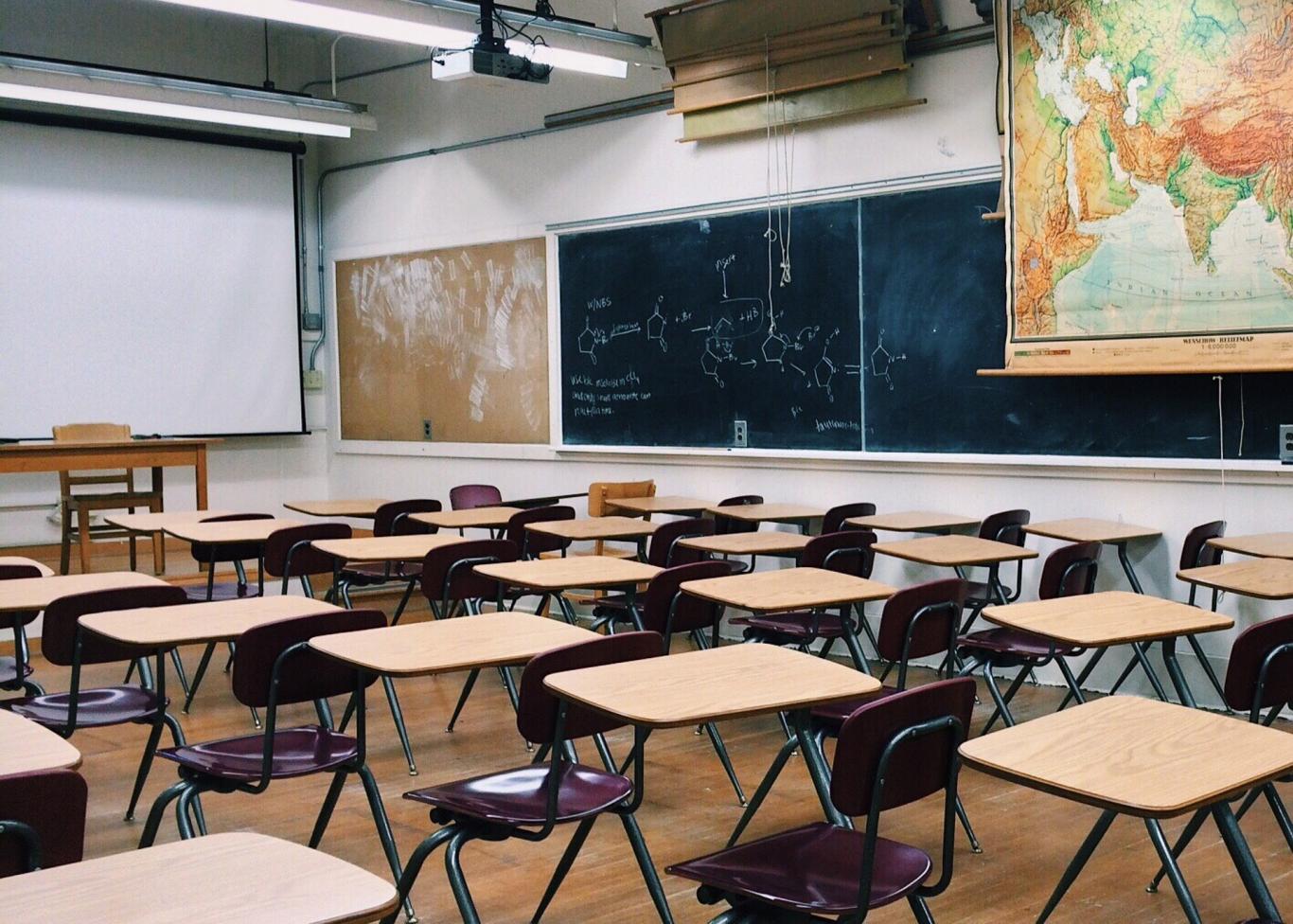 Aula formativa, con mesa, sillas y pizarra