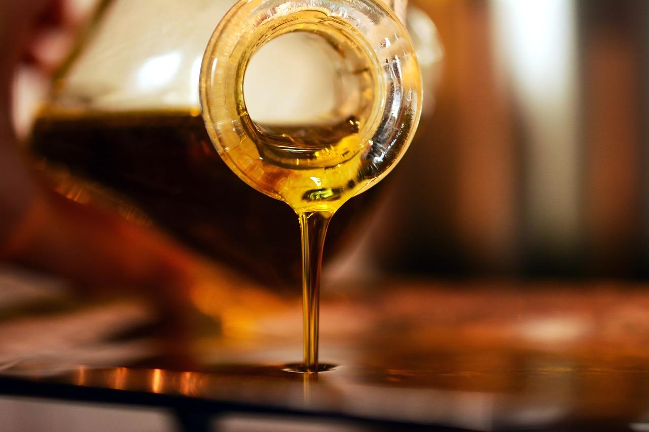 Aceite de oliva Aceite de oliva cayendo desde un círculo de cristal a una superficie