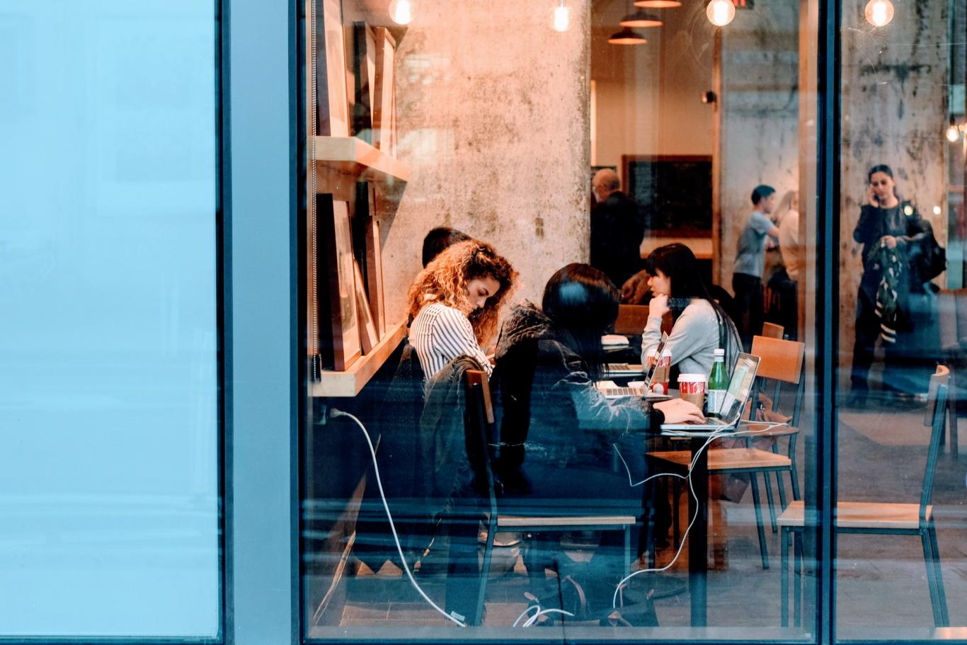 Jóvenes en una mesa trabajando con ordenador