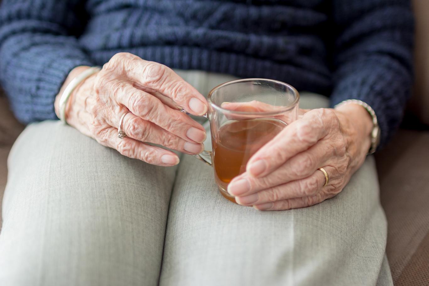 Señora mayor sentada tomando infusión