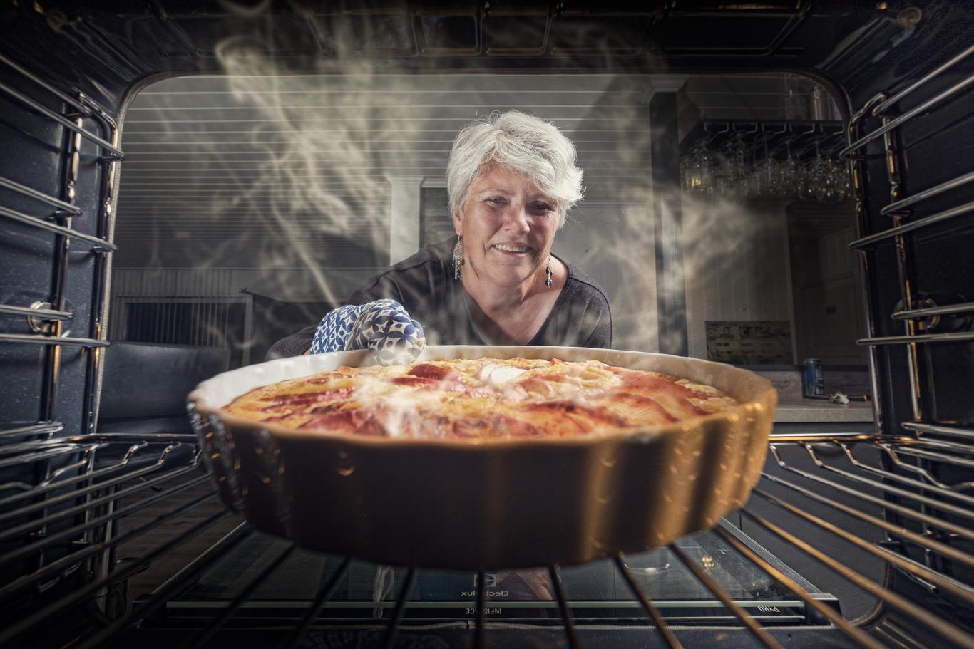 señora sacando del horno una tarta de manzana