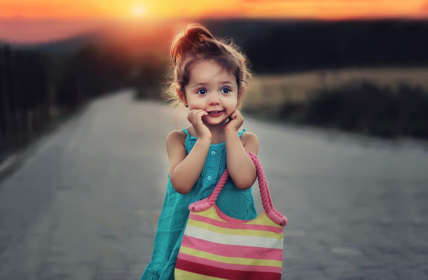Niña con bolsito al atardecer