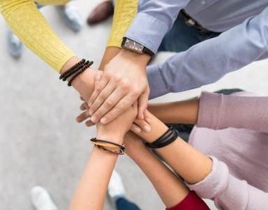 Manos unidas cuatro personas uniendo sus manos