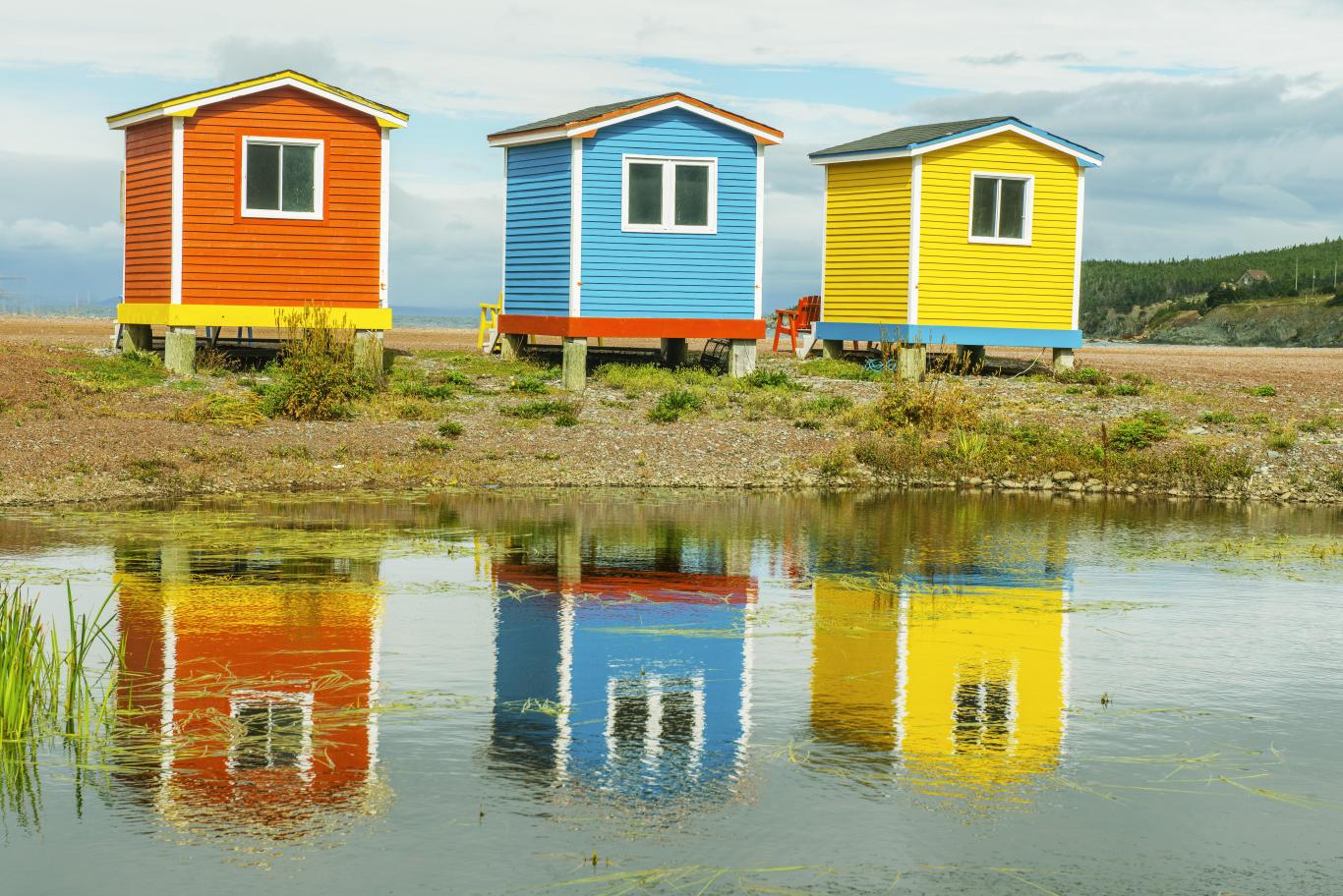 Casetas de madera de colores con reflejos en el agua