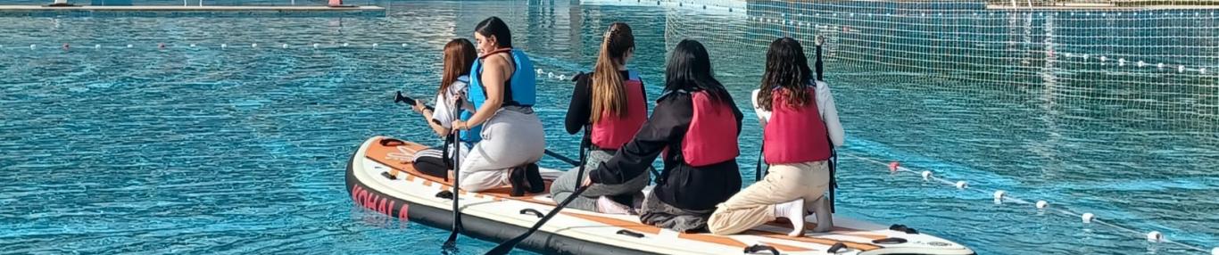 Jóvenes haciendo kayak polo en una piscina