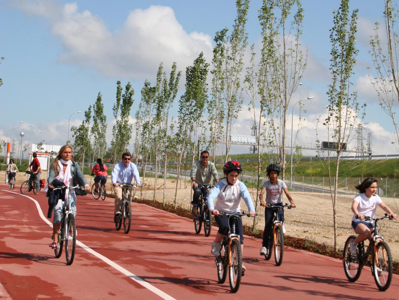 Imagen de ciclistas, adultos y niños, circulando por el carril bici del Anillo Ciclista