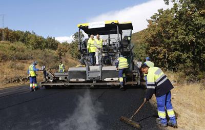 obreros trabajando con maquinaria asfaltando en la M-601