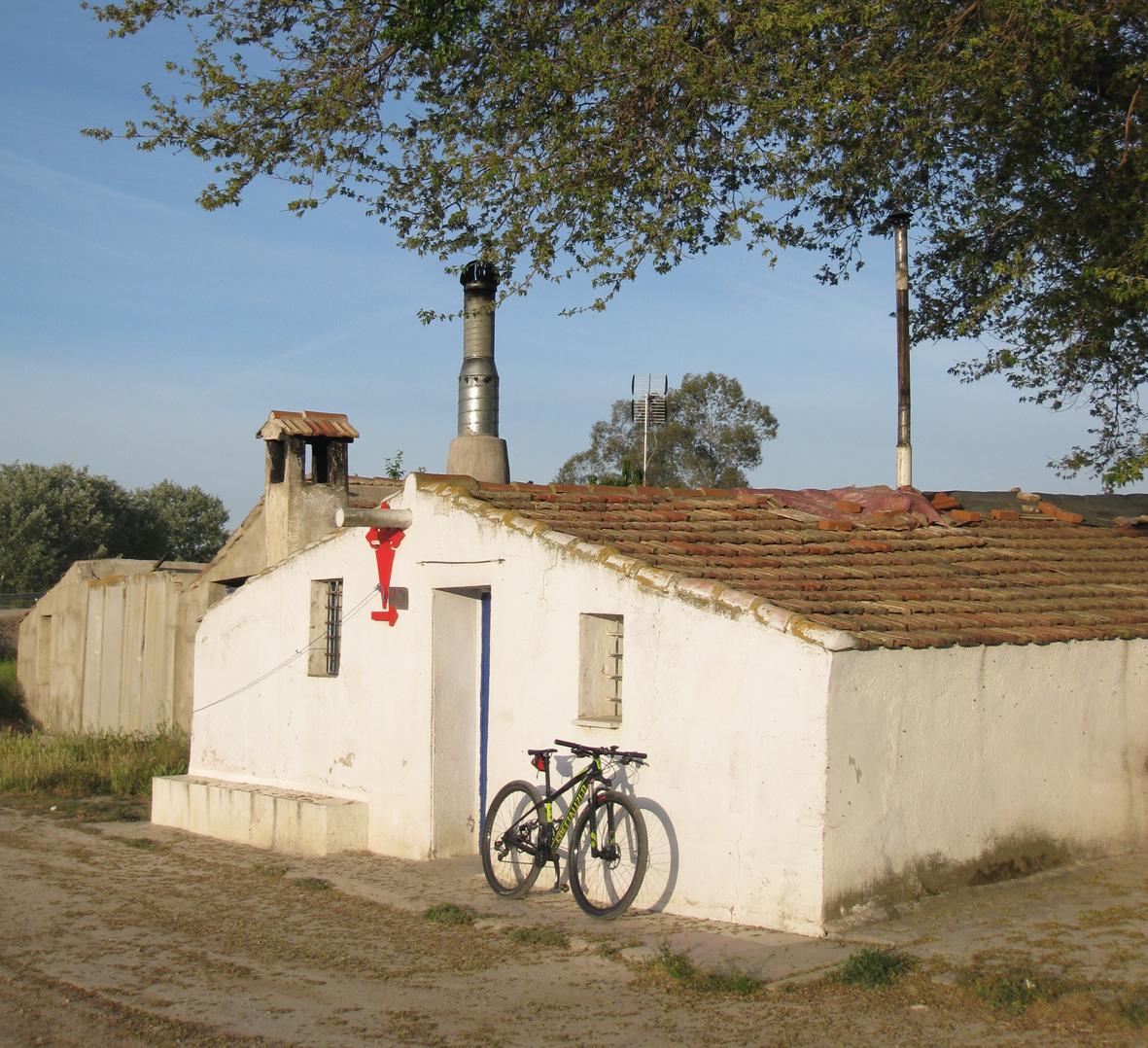 Casita encalada en el camino a Uclés con bicicleta apoyada en su fachada