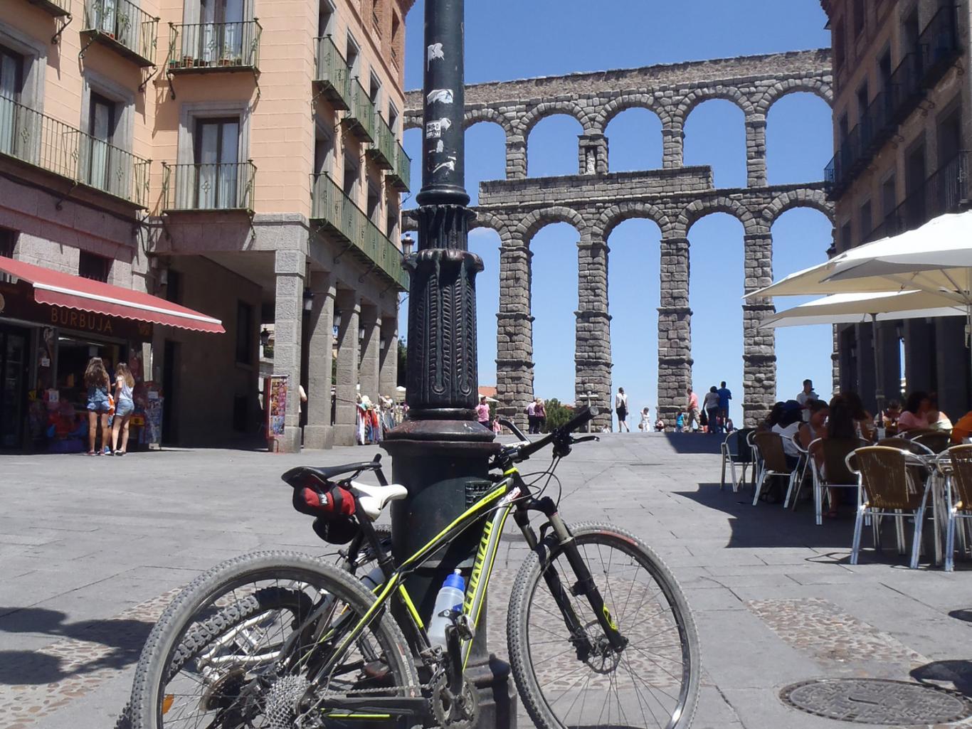 Bicicletas apoyadas en una farola delante del Acueducto de Segovia