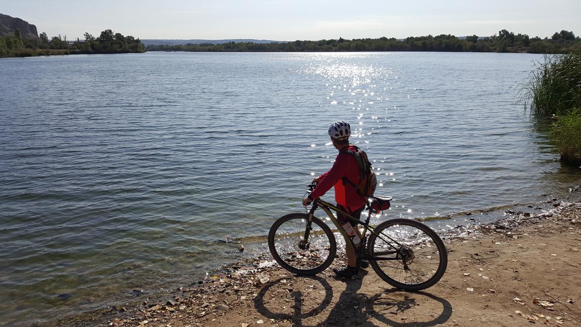 Ciclista parado delante de la laguna del Campillo