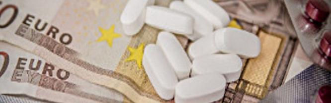 Billete de dinero entre comprimidos sueltos de un medicamento