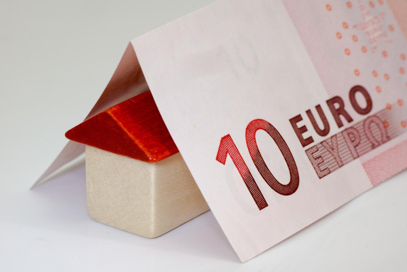 Imagen de casa de madera con billete