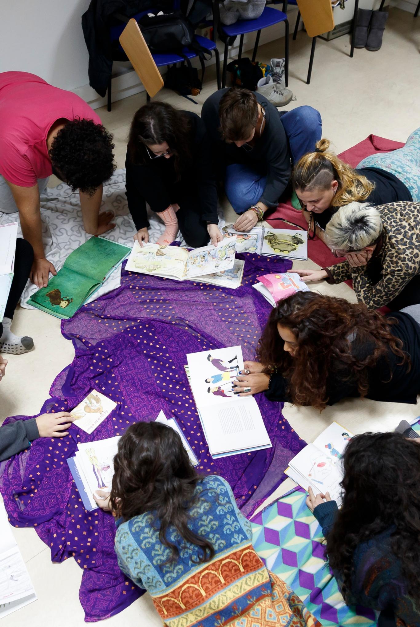 Grupo de jóvenes en el suelo leyendo libros