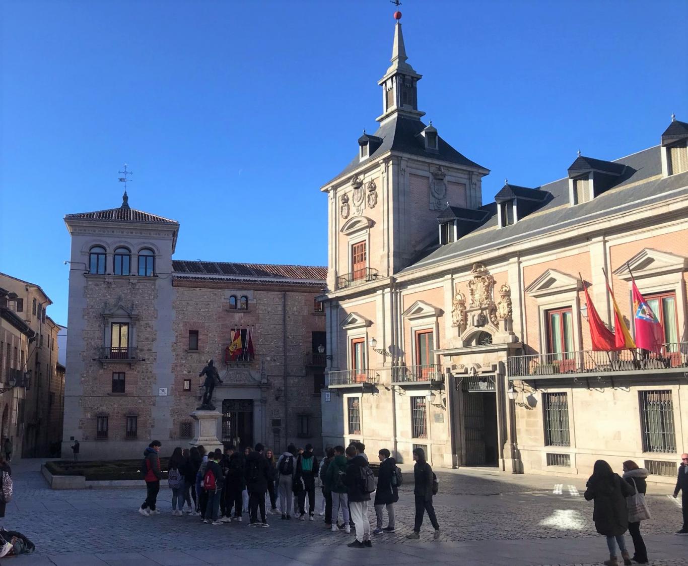 Grupo de jóvenes en una plaza con edificios históricos en Madrid