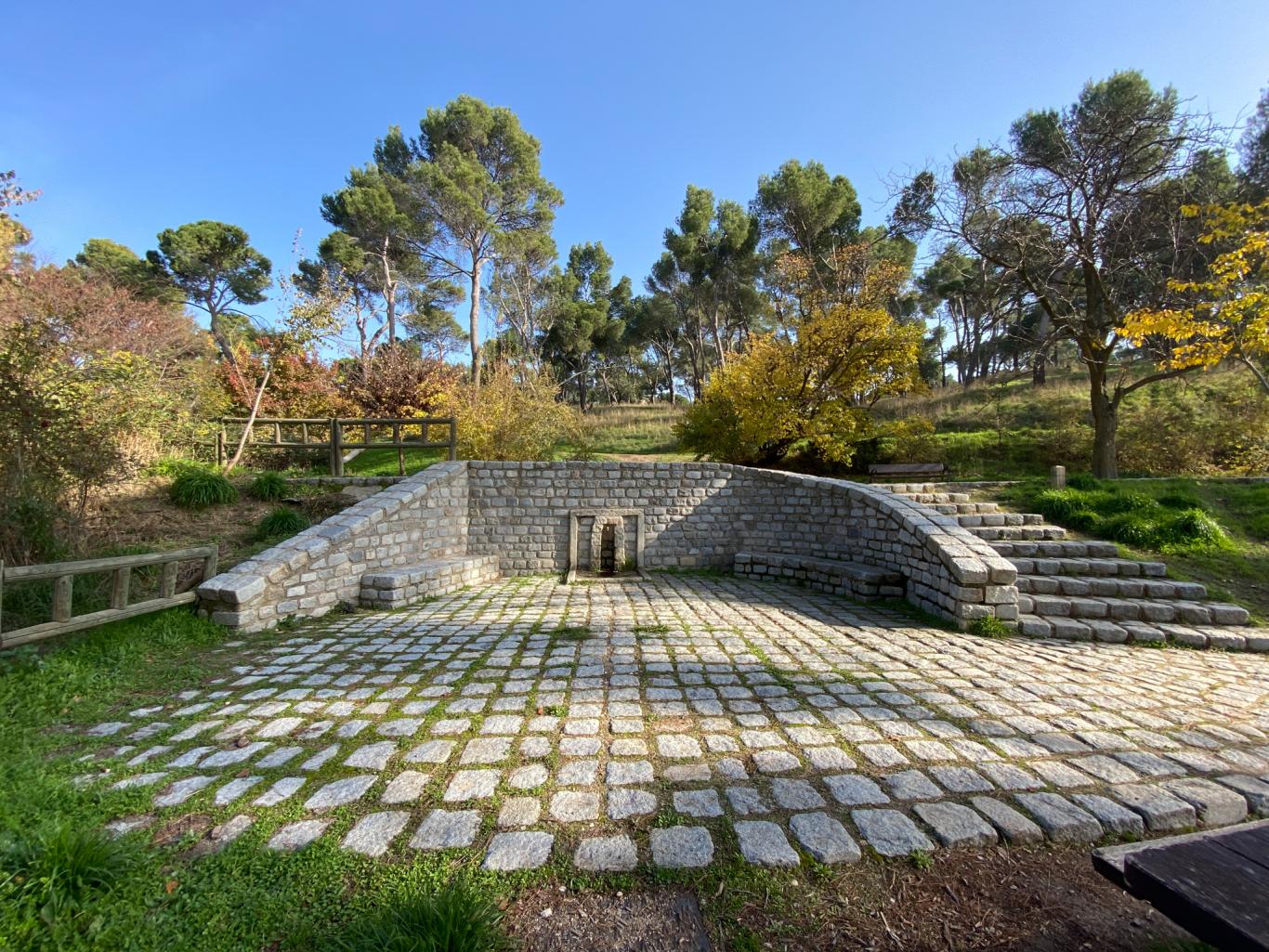 Fuente con un suelo, muro y escalera empedrados