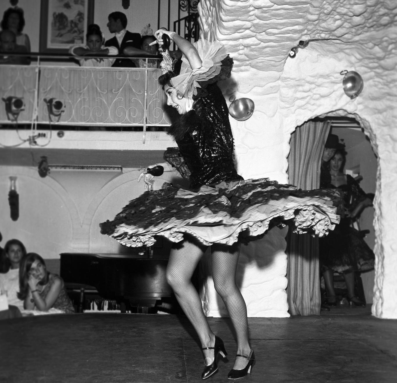Bailaora de flamenco bailando con los brazos en alto tocando las castañuelas