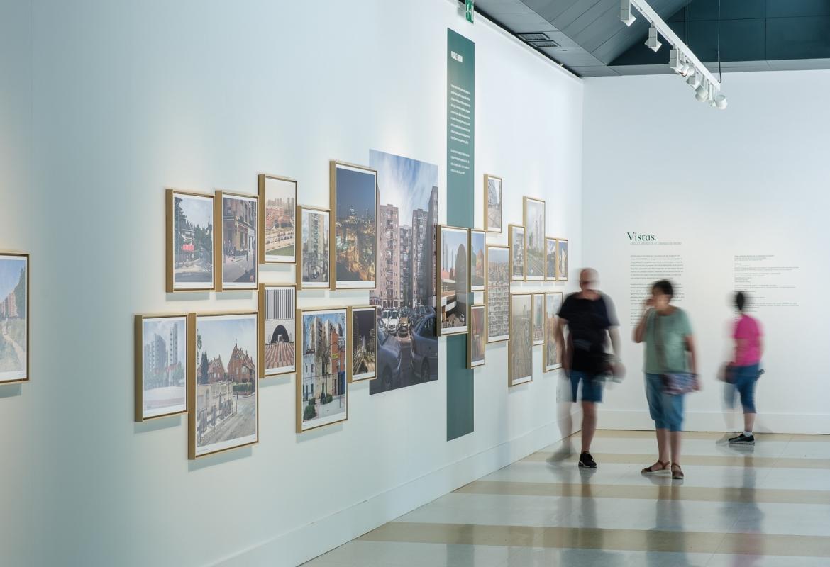 Varios visitantes en la muestra Vistas Paisajes urbanos de la Comunidad de Madrid