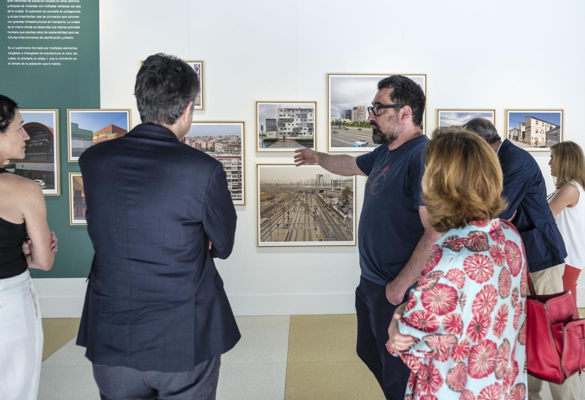 Varias personas atienden a la explicación de la muestra Vistas Paisajes urbanos de la Comunidad de Madrid