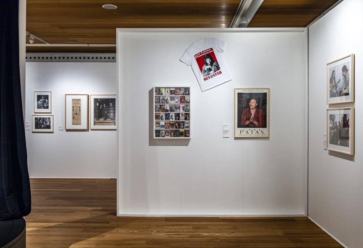Panorámica de la sala de exposiciones En primer plano carteles, fotografías y una camiseta
