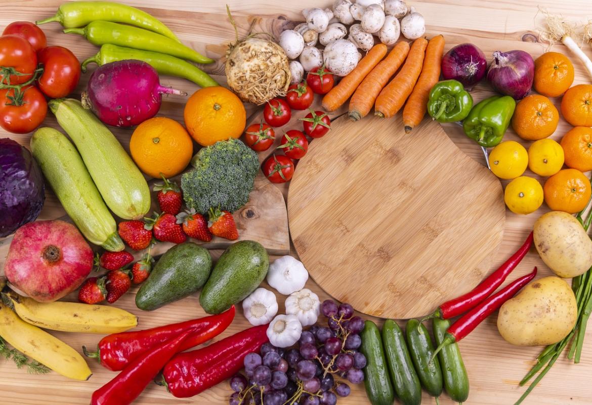 Frutas y verduras en una mesa con una tabla de madera