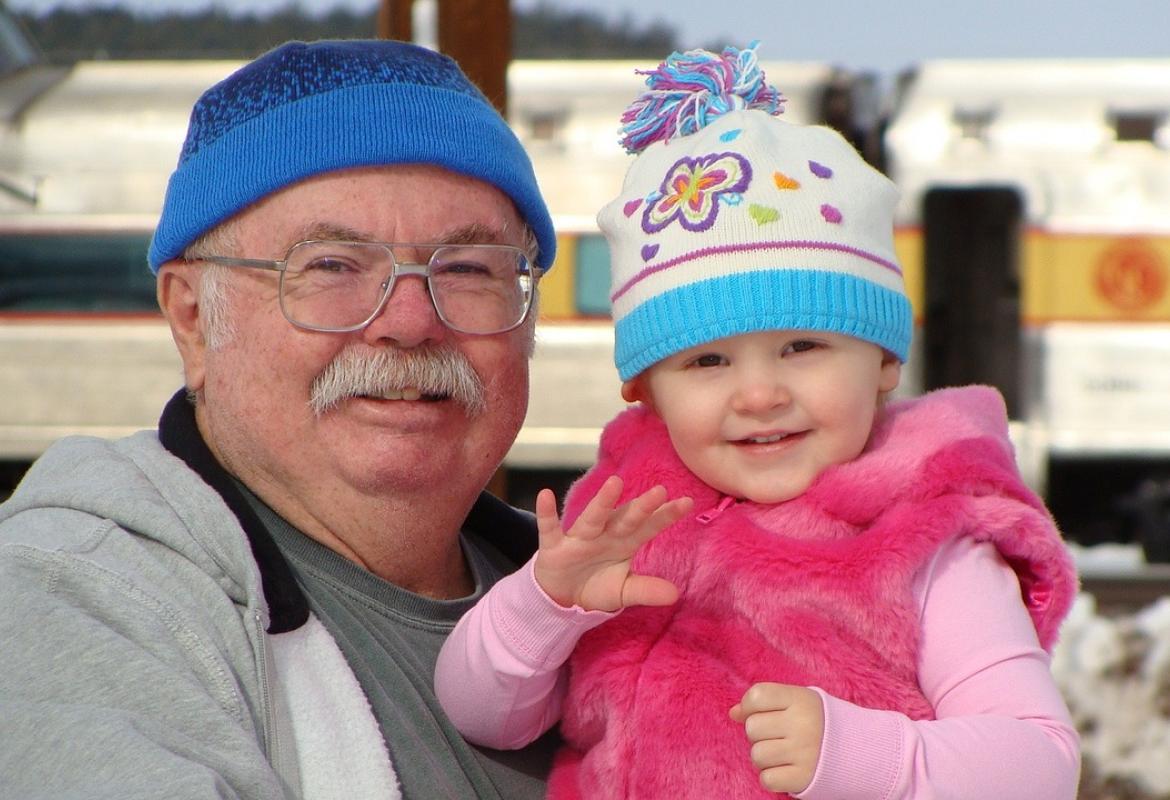 Abuelo con nieta en invierno abrigados y con gorro