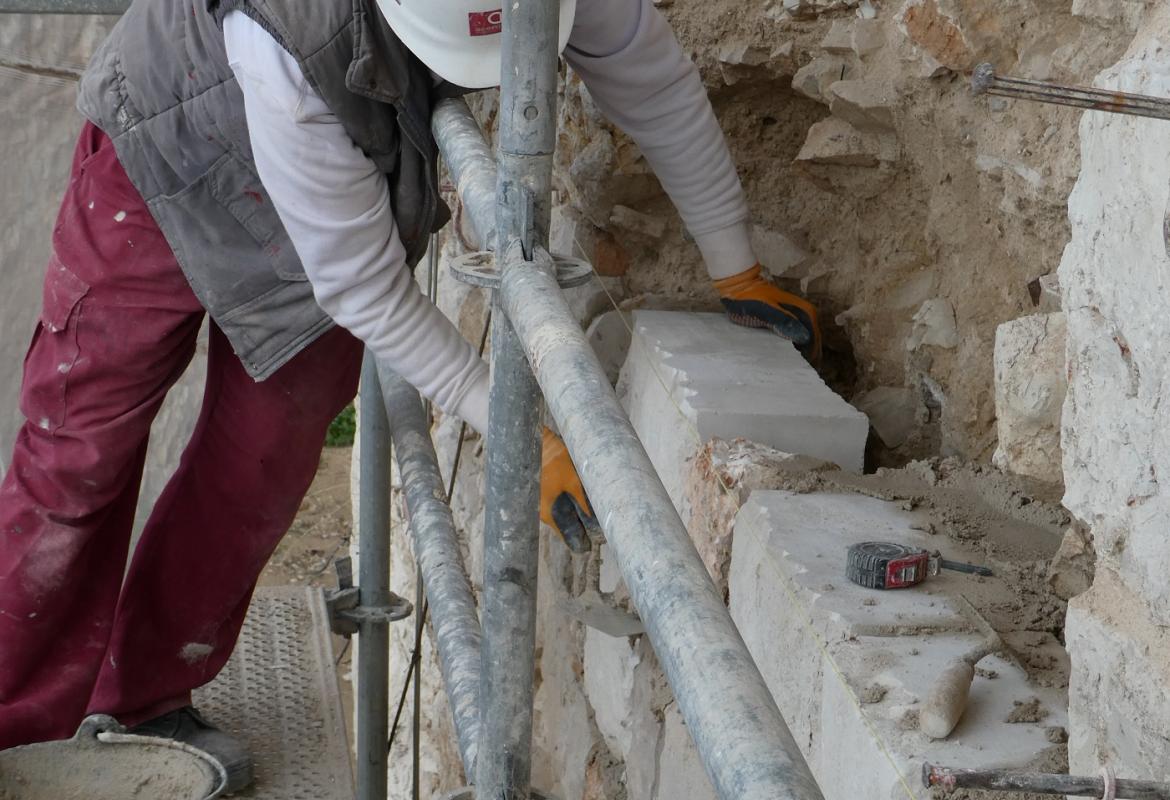 operario de restauración interviniendo en la muralla